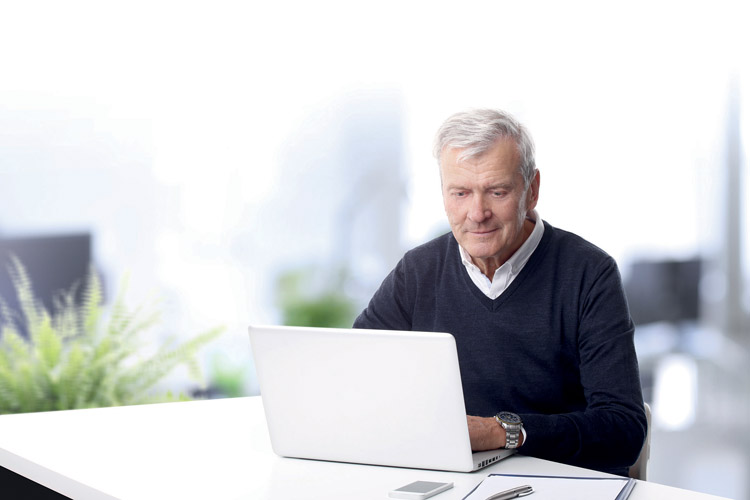 Mann sitzt vor einem Laptop