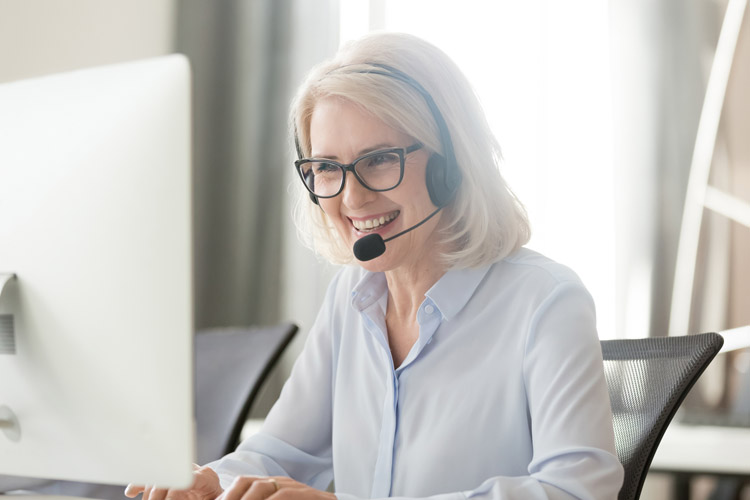 Frau sitzt am PC und telefoniert